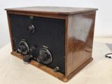an old fashioned radio sitting on a table with a laptop in the background