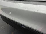 the front bumper of a white car with scratches on it