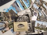 a pile of postcards sitting on a desk next to a keyboard