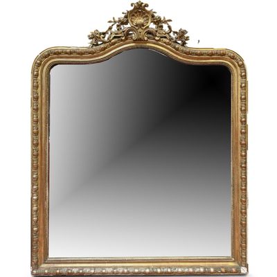 un miroir à cadre doré orné d'un motif décoratif dans sa partie supérieure
