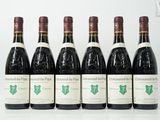 six bouteilles de vin sont alignées sur une table