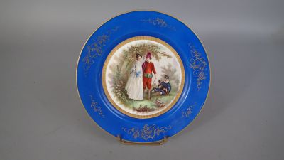 une assiette bleue sur laquelle est représenté un homme et une femme