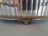 a silver plate with a handle on it on a table