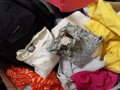 a box full of clothes and a backpack sitting on the floor