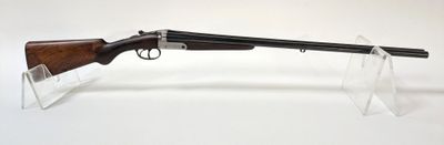 un gros plan d'un fusil posé sur un support transparent, sur une surface blanche