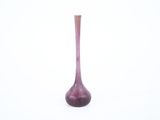 un vase violet posé sur une surface blanche