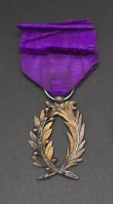 un ruban violet orné d'une couronne argentée et d'un ruban violet
