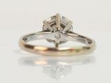 a close up of a diamond ring on a white surface