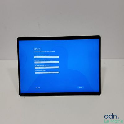une tablette posée sur une table, dont l'écran est bleu