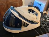 a blue and white steam iron sitting on a counter