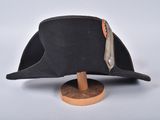 hat on a wooden stand on a white surface with a white background