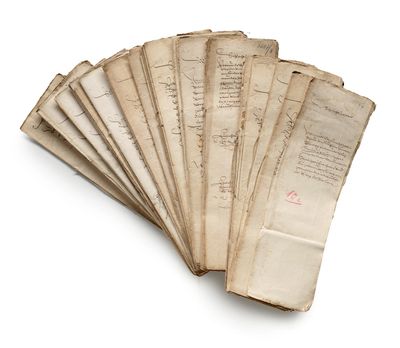 several old papers are stacked on top of each other on a white surface