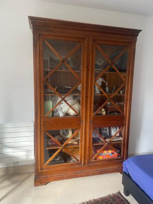 un lit et une armoire dans une pièce où il y a un tapis au sol
