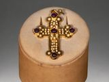 gold and amethoral cross with amethoral stones in a wooden box