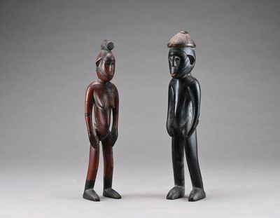 deux figurines en bois représentant un homme et une femme debout l'un à côté de l'autre
