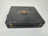 an old black suitcase sitting on top of a white table