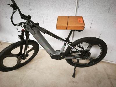 un vélo garé dans un garage, avec une boîte posée sur la selle