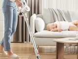 une femme qui passe l'aspirateur sur un bébé