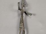 une petite figurine en métal représentant un homme coiffé d'un chapeau