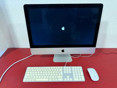 a computer on a red desk with a keyboard and mouse