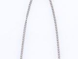a close up of a necklace on a white surface with a chain
