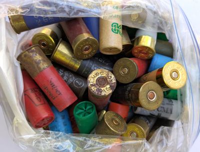 un sac en plastique rempli de différentes sortes de cartouches de fusil de chasse