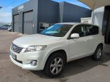 La Toyota RAV blanche est garée devant un immeuble.