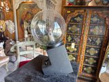 a glass ball on top of a metal stand