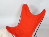 a red butterfly chair and a white sock on a white background