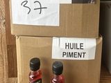 two bottles of olive oil on a table next to a cardboard box