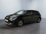 La voiture noire est garée dans une pièce aux murs blancs.