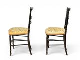 pair of black chairs with floral upholstered seat cushions