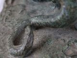 a close up of a statue of a snake on the ground