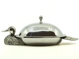 une assiette en argent sur laquelle est posé un canard