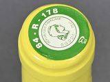a close up of a yellow container with a green label on it