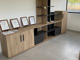 une pièce avec un bureau, des étagères et des tableaux accrochés au mur