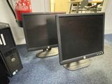 two computer monitors sitting on the floor next to each other