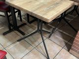 tables and chairs in a restaurant with brick walls and tiled floor