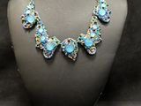 a close up of a necklace and earrings on a mannequin