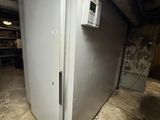 a white refrigerator in a dirty room with a light on