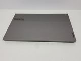 the back of a laptop with a silver cover sitting on a white surface