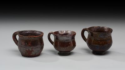 trois tasses marron posées les unes à côté des autres sur une table