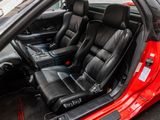 a red sports car with black leather seats in a parking lot