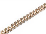 a close up of a gold bracelet on a white background