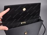 the hand is holding a black purse with a chain around it