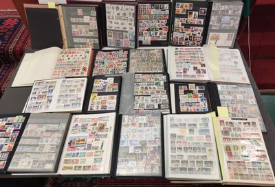 beaucoup de timbres posés sur une table, avec de nombreux classeurs