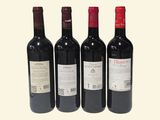 three bottles of red wine sit next to each other on a white surface