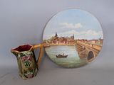 a picture of a painting on a plate next to a vase