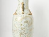 a white vase with a gold decoration on it