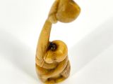 a figurine of an elephant holding a ball in its trunk